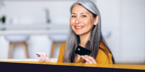 Woman holding a payment card and smiling